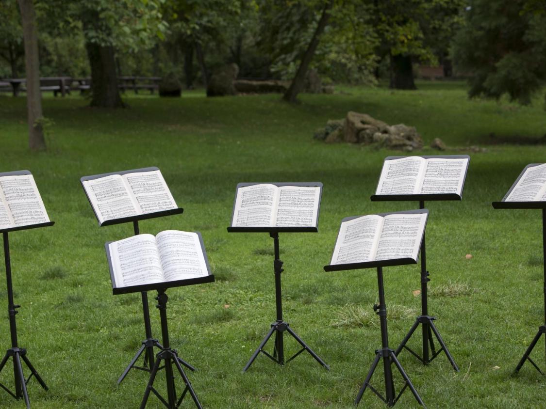 Das Bild zeigt viele Notenständer mit Noten für ein Konzert