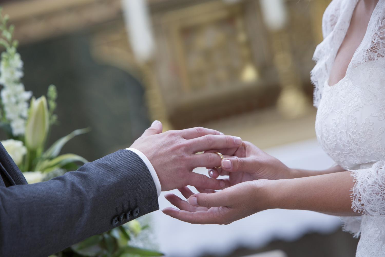 Die Braut steckt dem Bräutigam den Trauring an den Finger